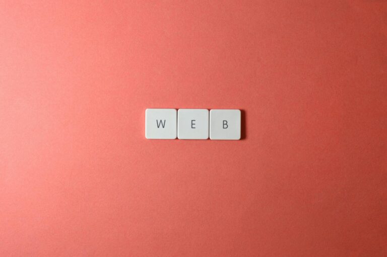 A minimalist photo featuring the word 'WEB' spelled with keyboard keys on a red background.
